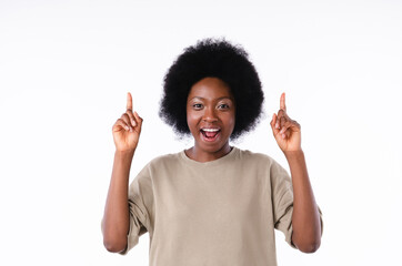Excited african teenage girl pointing at copy space isolated in white background