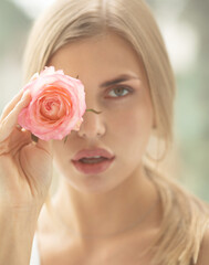 Beautiful blonde woman with fragile rosebud. Perfect skin, beauty concept.