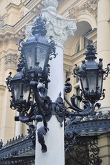 textured lamppost near the theater building with a large number of forged leaves monograms and...