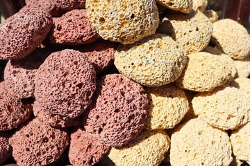 multicolored pumice stone in wicker baskets on wooden tables