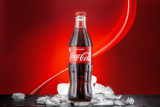 MOSCOW, RUSSIA - May 5, 2020: Classic bottle Of Coca-Cola on the bright colored background with ice.