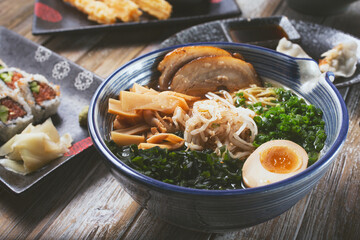 A view of a ramen bowl, featuring a variety of popular Japanese appetizers in the background.