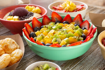 A view of a large fruit bowl, among other delicious sweet and savory sides found in a Brazilian cafe.