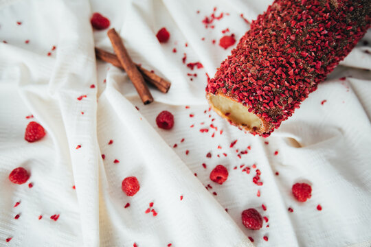 New Kurtos Kalacs, traditional Hungarian food, also known as chimney cake with amazing cinnamon and raspberry flavor on a rustic tablecloth. 