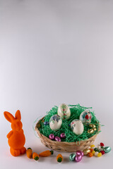 Orangefarbener Hase mit einem gefüllten Osternest  und süßen Eiern
