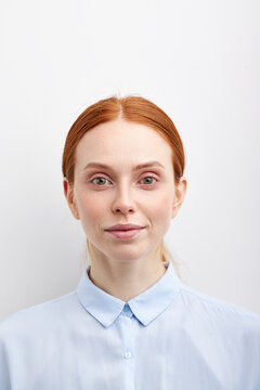 Smiling caucasian young businesswoman wear blue formal shirt looking at camera isolated on white studio background