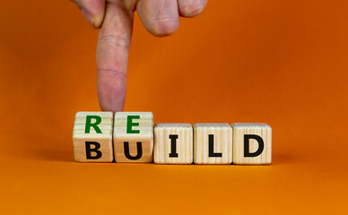 Rebuild symbol. Concept word 'rebuild' on wooden cubes on a beautiful orange table. Businessman...