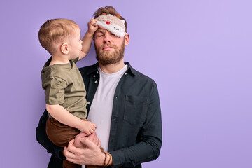 young father in eye mask for sleep doesn t want to take the child to kindergarten in morning