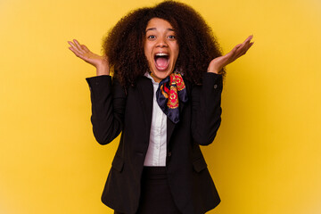 Young African American air hostess isolated on yellow background celebrating a victory or success,...