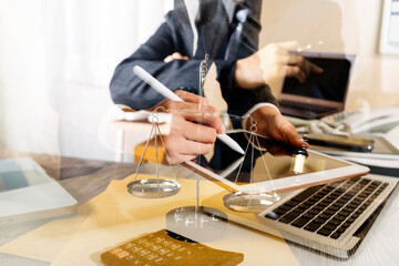 Business and lawyers discussing contract papers with brass scale on desk in office. Law, legal services, advice, justice and law concept picture with film grain effect