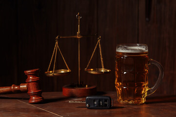 Glass of beer, car keys and wooden judge gavel in a notary office. Alcohol and law concept