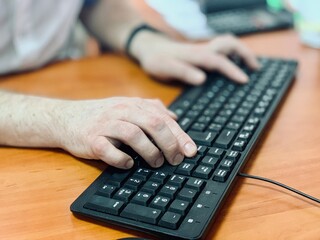 Office manager male hands typing on computer keyboard, closeup. Businessman working, no face, two hands on wireless keyboard. Concept of office work