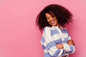 Young african american woman isolated on pink background smiling confident with crossed arms.