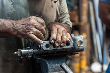 m&atilde;os de mec&acirc;nico trabalhando