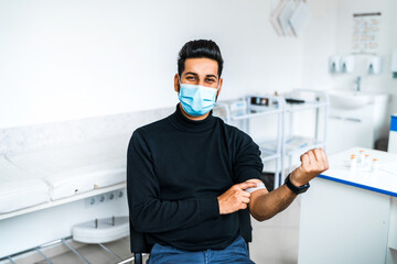 Satisfied happy patient after vaccination. Vaccine against covid 19. An Asian man in a protective mask was vaccinated, health safety