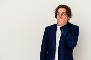 Young business man isolated on white background thoughtful looking to a copy space covering mouth with hand.