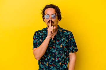 Fototapeta premium Young caucasian man wearing summer clothes isolated on yellow background keeping a secret or asking for silence.