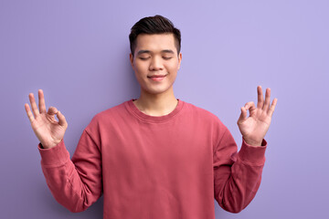 calm asian male meditating, keep calm in yoga pose with eyes closed