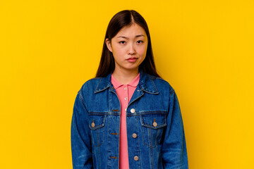 Young chinese woman isolated on yellow background sad, serious face, feeling miserable and displeased.