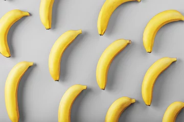 Helles Muster gelber Bananen auf grauem Hintergrund, modische Farben von 2021. © Alexander