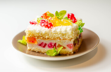 A portion of cream cake with pieces of colorful jelly and sprinkled with coconut flakes