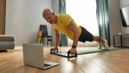 Middle aged sportsman using push up training system