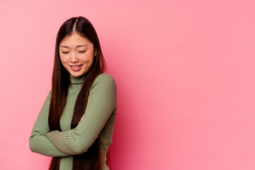 Fototapeta premium Young chinese woman isolated on pink background smiling confident with crossed arms.