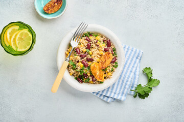 Mexican black bean corn quinoa salad with caramelized lemon in old vintage clay bowl on a light gray concrete background. Traditional Mexican cuisine dish. Top view, mock up.