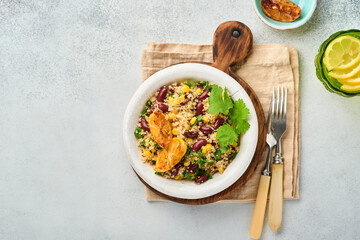 Mexican black bean corn quinoa salad with caramelized lemon in old vintage clay bowl on a light gray concrete background. Traditional Mexican cuisine dish. Top view, mock up.