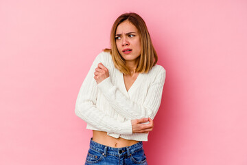 Young caucasian woman isolated on pink background confused, feels doubtful and unsure.