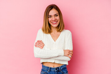 Young caucasian woman isolated on pink background who feels confident, crossing arms with determination.