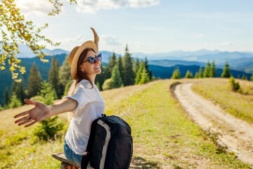 Trip to Carpathian mountains. Woman hiker relaxing admiring landscape with arms raised. Traveling in summer Ukraine