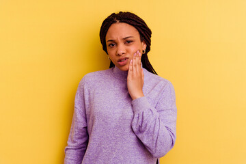 Young african american woman isolated on yellow background having a strong teeth pain, molar ache.