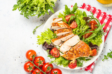 Grilled chicken with fresh salad at table.