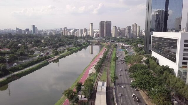 Drone aerial view of Marginal Pinheiros Avenue landscape, river, car traffic, buildings cityscape and Sao Paulo city skyline.	 Brazil. Concept of urban, metropolis, corporate, pollution, transport. 4K