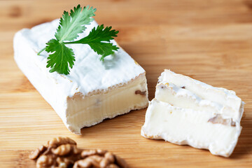cheese with nuts on a wooden background, the concept of making homemade cheese with walnuts