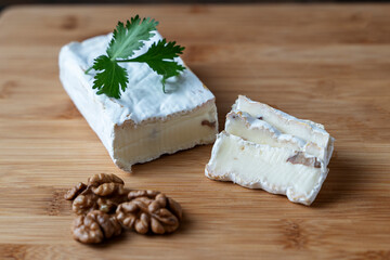 cheese with nuts on a wooden background, the concept of making homemade cheese with walnuts