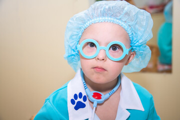 A boy with Down's syndrome plays a role-playing game, a genetically ill disabled child dressed as a...