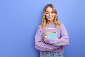 Sweet friendly young student girl in casual shirt holding colorful exercise books