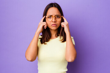Young mixed race woman isolated focused on a task, keeping forefingers pointing head.