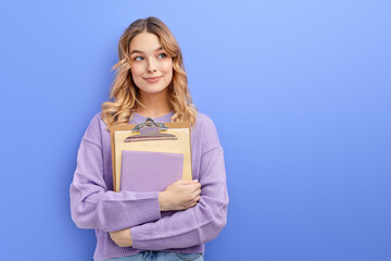 Smiling teen student girl hold books isolated on pastel blue background studio portrait