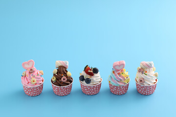 Colorful cupcakes isolated in blue background