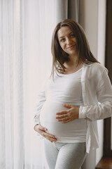 Pregnant woman hugging belly in anticipation of baby