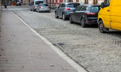 Poland Krakow old cobbled street car lane, footpath
