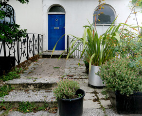 entrance and part of building with white façade and blue door