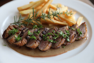 Duck magret confit with chips on wood table