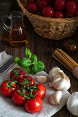 Italian food background with tomatoes, basil, spaghetti, olives, garlic.