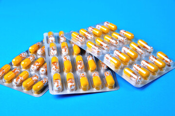 capsules in a blister, a medicine, tablets, vitamins in the form of granules in a yellow capsule on...