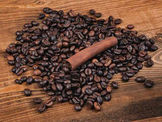 Freshly roasted coffee beans and a cinnamon stick