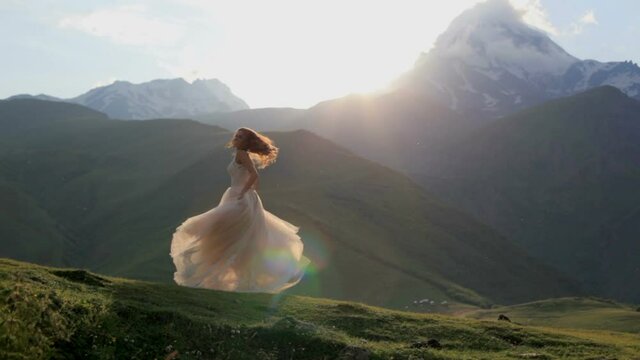 Beautiful girl dances in the evening against the backdrop of the mountains. Slow motion. Beautiful princess
